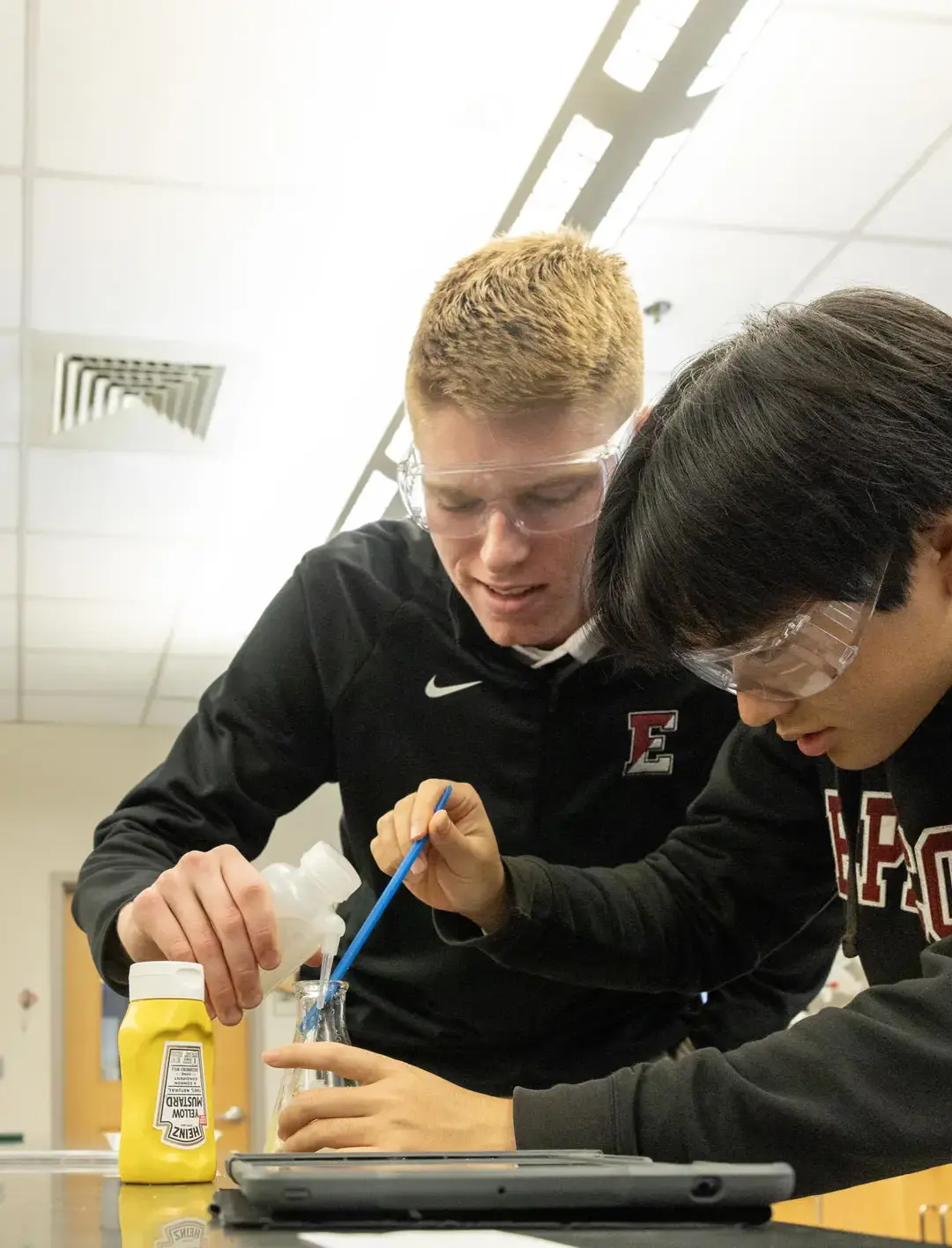 Two students engaged in a hands-on chemistry experiment in a well-equipped science lab, demonstrating collaboration and experiential learning at Episcopal High School.