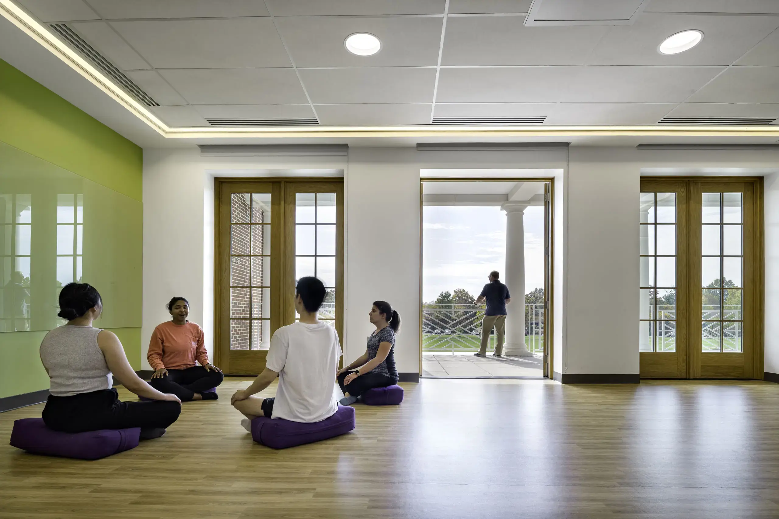 Students participate in a mindfulness and meditation session in a bright, modern wellness space.