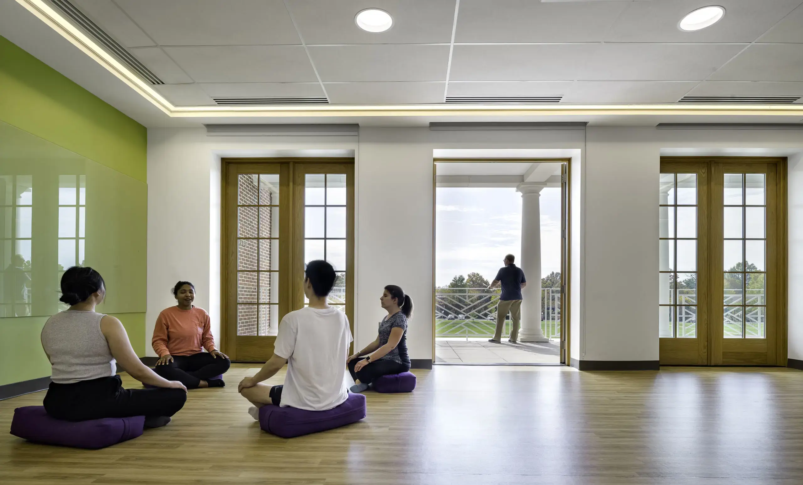 Students participate in a mindfulness and meditation session in a bright, modern wellness space.